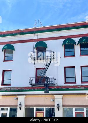 Una vista esterna di un hotel originale del 1900s con fughe di fuoco e coperture verdi delle finestre a Reno, Nevada Foto Stock