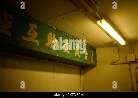 Un primo piano di un cartello in cinese in un corridoio di una vecchia tenuta pubblica di alloggi a Hong Kong Foto Stock