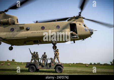 I soldati statunitensi agganciano un veicolo militare a un elicottero CH-47 Chinook per caricare le imbracature durante un corso U.S. Pathfinder a Camp Dodge a Johnston, Iowa, il 8 settembre 2022. Quasi 30 soldati si sono laureati al corso, che è stato insegnato da una squadra di addestramento mobile presso il Centro di addestramento della Guardia Nazionale dell'Armata a Fort Benning, Georgia. I Pathfinder dell'esercito sono addestrati a fornire aiuti alla navigazione e servizi di consulenza agli aeromobili militari nelle aree designate dai comandanti di unità supportati. Durante il corso Pathfinder, gli studenti vengono istruiti in orientamento aereo, evacuazione aeromedica, combattimento ravvicinato Foto Stock