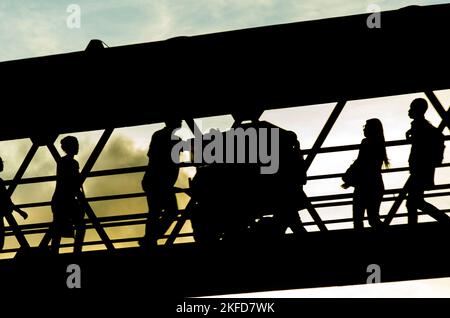 Silhouette di pedoni che camminano sulla passerella contro il tramonto nella città di Salvador, capitale di Bahia, Brasile. Foto Stock