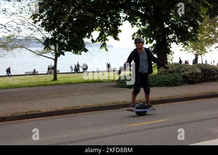 Un giovane uomo sullo skateboard elettrico Foto Stock