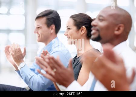 Seminario informativo. Il team di colleghi felici applaude durante una riunione di lavoro. Foto Stock