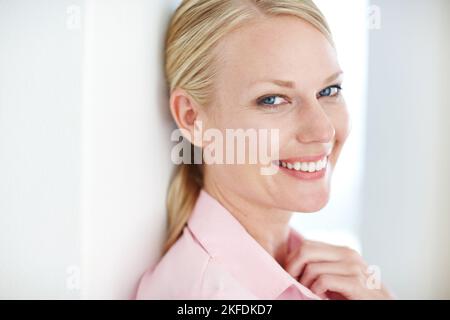 Ama essere la sua propria sporgenza. Primo piano di una giovane donna d'affari allegra appoggiata a un muro. Foto Stock