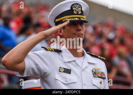 220909-N-FP878-0005 OXFORD, OHIO (SET. 10, 2022) - CMdR. Erik Moss, funzionario esecutivo della Navy Talent Acusiition Group Ohio River Valley (NTAG ORV), saluta durante la riproduzione dell'inno nazionale prima della partita di Miami contro Rober Morris allo Yager Stadium. NTAG ORV copre l'Ohio, il West Virginia Kentucky e parti di Indianna per il reclutamento e l'attività della Marina militare per le aree di concentrazione della flotta anone. Foto Stock