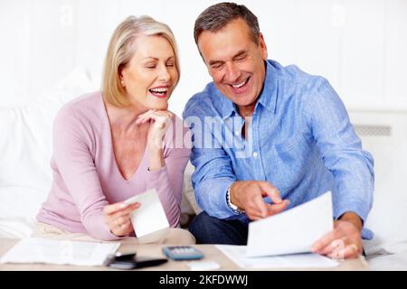 Uomo e donna anziani che guardano le loro spese quotidiane. Ritratto di un uomo anziano allegro e moglie che guarda le loro spese quotidiane. Foto Stock