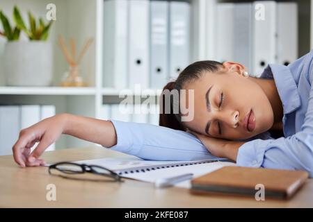 Stanco, dorme e donna in affari sul suo tavolo sensazione di burnout e sovraccarico di lavoro mentre dorme nel suo ufficio. NAP, sognando ed esausto con fatica Foto Stock