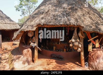 Villaggio culturale Shangaan tradizionale capanna di paglia africana con souvenir o ricordi appesi all'esterno in mostra per i turisti a comprare in Sud Africa Foto Stock