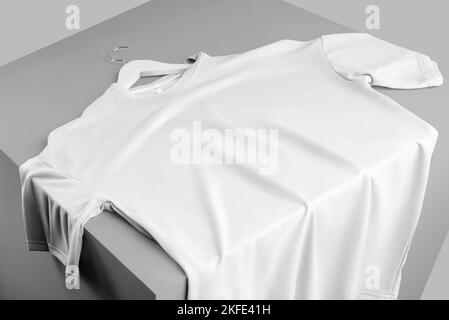 Mockup di una t-shirt bianca oversize, ripiegata su un cubo, vista frontale, con spazio per il design, il motivo, la pubblicità in un negozio online. Modello bl Foto Stock
