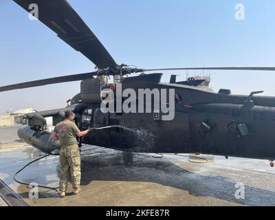 Sgt. Dell'esercito degli Stati Uniti Kyle Eddy, nativo di Pittstown, NY, e capo dell'equipaggio di Alpha Company, 3-142nd Battaglione di elicotteri d'assalto (AHB), con sede a Ronkonkoma, NY, lava un elicottero UH-60m Black Hawk come parte della manutenzione giornaliera a Camp Buehring, Kuwait, 11 settembre 2022. Gli elicotteri del battaglione devono essere lavati periodicamente per evitare la corrosione dei componenti degli aerei e il degrado delle prestazioni dovuto alla forte polvere in Medio Oriente. 3-142nd AHB, associata a 36th Brigata dell'aviazione di combattimento, sostiene attualmente la missione congiunta congiunta di consulenza, assistenza, operazione inerente alla risoluzione, Foto Stock