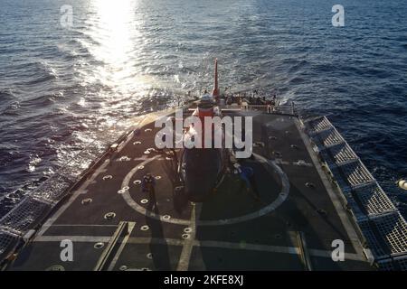 I membri dell'equipaggio assegnati all'USCGC Mohawk (WMEC 913) rimuovono le cinghie di ancoraggio sull'elicottero MH-65 Dolphin mentre sono in corso nell'Oceano Atlantico, il 11 settembre 2022. L'equipaggio dell'elicottero MH-65 Dolphin partì dal Mohawk per un viaggio di ritorno di due giorni alla stazione aerea della Guardia Costiera di Houston. Foto Stock