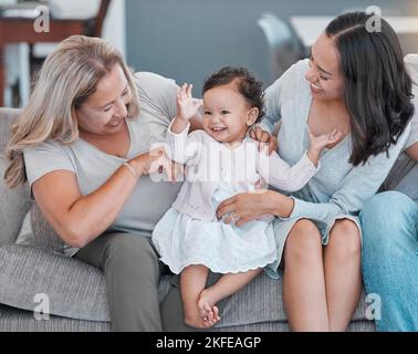 Casa di famiglia, amore e bambino, madre e nonna con felicità sul divano del soggiorno per amore, cura e divertimento mentre eccitato, felice e ballare Foto Stock