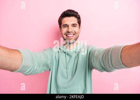 Selfie primo piano cadre foto di allegro positivo toothy fascio sorriso uomo tenere fotocamera bel umore godere del suo stile di vita isolato su colore rosa brillante Foto Stock