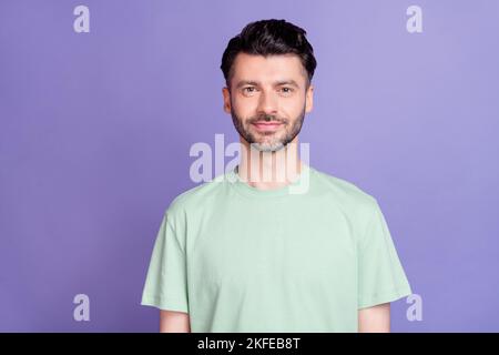 Foto di un bel ragazzo ottimista positivo con una maglietta a taglio di capelli brunetto isolata su sfondo di colore viola Foto Stock