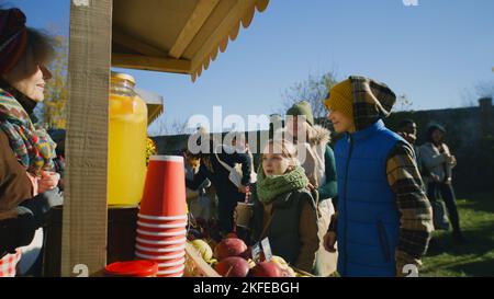 Madre con due figli che comprano anguria. Shopping al mercato agricolo locale. Fiera autunnale nei fine settimana all'aperto. Cibo vegetariano e biologico. Agricoltura. Sistema dei punti vendita. Foto Stock