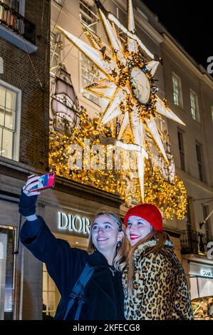 Londra, Regno Unito. 17th Nov 2022. Un selfie di fronte al Dior Store - le luci di Natale sono accese sopra Bond Street e sul fronte del negozio di molti dei buoni negozi di lusso con sede lì. Credit: Guy Bell/Alamy Live News Foto Stock