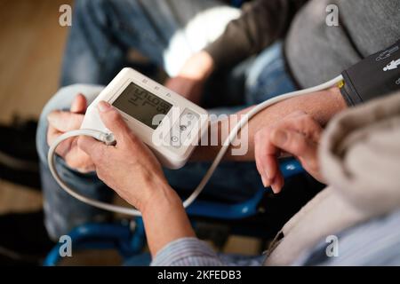 Le persone controllano la pressione sanguigna e la frequenza cardiaca con la misurazione digitale. Concetto di personale sanitario Foto Stock