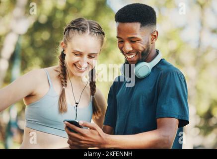 Fitness, social media e coppia con il telefono in un parco per la formazione, app mobile e video divertenti. Comunicazione, commedia e nero uomo e donna lettura Foto Stock