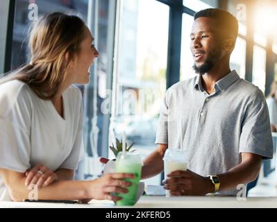 Ristorante, data e coppia bere milkshake mentre si parla, si legano e ridono insieme. Felice, amore e interrazziale uomo e donna in conversazione Foto Stock