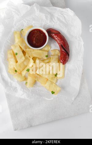 Fettine di yam fritto, salsiccia e salsa, fettine di yam fritto e stufato su carta da pergamena, patatine fritte nigeriane Foto Stock