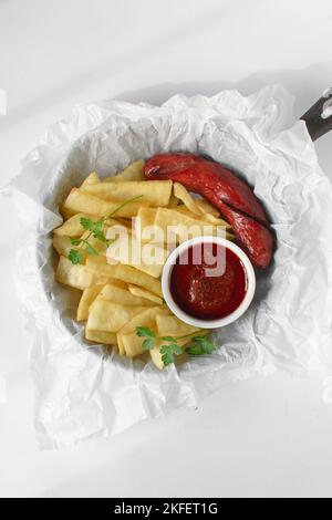 Fettine di yam fritto, salsiccia e salsa, fettine di yam fritto e stufato su carta da pergamena, patatine fritte nigeriane Foto Stock