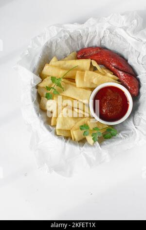 Fettine di yam fritto, salsiccia e salsa, fettine di yam fritto e stufato su carta da pergamena, patatine fritte nigeriane Foto Stock