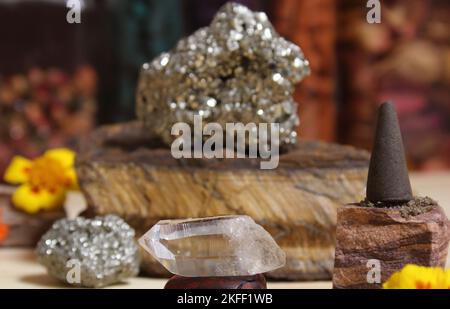 Cono di incenso su pietra con cristalli e fiori Foto Stock