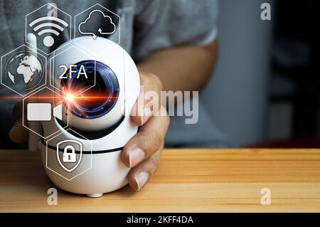 Il concetto di utilizzare le telecamere IP per la sicurezza, la telecamera ip bianca si trova su un pavimento in legno, uomo che utilizza la telecamera ip Foto Stock