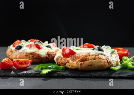 Pizza fatta in casa con verdure per colazione su sfondo nero con spazio vuoto per il testo Foto Stock