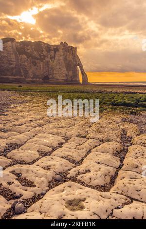 Vista panoramica delle scogliere di Etretat in Normandia Francia contro la luce dorata del tramonto Foto Stock
