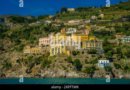 Aprile 15 2022-Costiera Amalfitana vista dal traghetto della città con il mare in primo piano e la costa con case colorate sullo sfondo e. Foto Stock