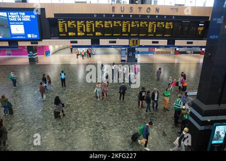 I passeggeri guardano il bordo elettrico alla stazione Euston di Londra il terzo giorno dello sciopero ferroviario. Foto Stock