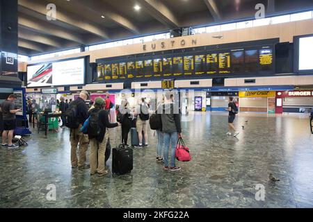 I passeggeri guardano il bordo elettrico alla stazione Euston di Londra il terzo giorno dello sciopero ferroviario. Foto Stock