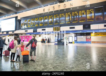 I passeggeri guardano il bordo elettrico alla stazione Euston di Londra il terzo giorno dello sciopero ferroviario. Foto Stock