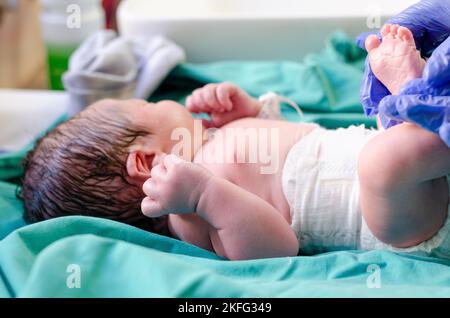 Un neonato che viene ripulito dopo la nascita. Foto Stock