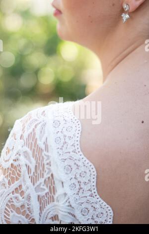 Il. retro di una sposa con il suo abito da sposa in pizzo nel suo giorno di nozze minimalistico Foto Stock