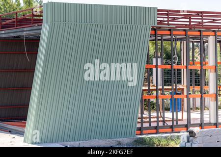 Edificio di recente costruzione incorniciato da metallo con siding. Costruzione di una nuova casa piccola. Fuoco selettivo Foto Stock