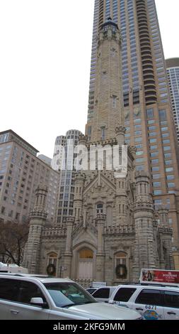 CHICAGO, ILLINOIS, STATI UNITI - 11 dicembre 2015: Vista esterna della storica torre dell'acqua con auto bianca in primo piano e grattacielo sullo sfondo Foto Stock