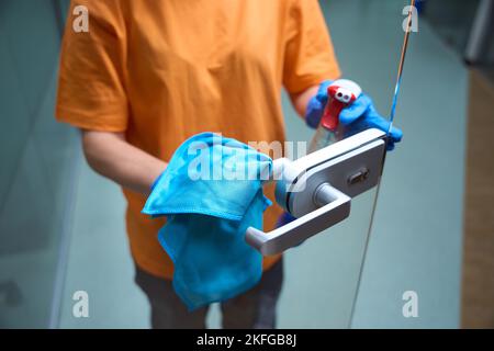 Detergente responsabile per igienizzare le maniglie delle portiere e pulire il vetro Foto Stock