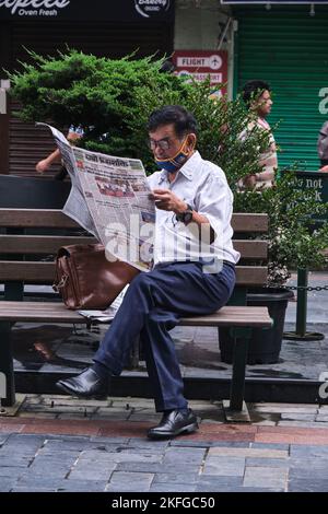 Gangtok, INDIA, 21 giugno 2022, uomo di mezza età che legge il giornale sul lato della strada. Foto Stock