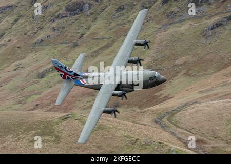 Machynlleth Galles Regno Unito. 50° anniversario RAF Hercules volare attraverso il Mach Loop a basso livello con colline sullo sfondo. Foto Stock