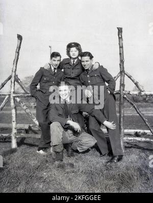 Anni '1940, in posa per una foto con tre uomini fuori Longford Camp, a RAF Tern Hill vicino a Market Drayton, Shropshire, Inghilterra, Regno Unito, una giovane donna WAAF con colletto e cravatta, tunica in tessuto di lana, pantaloni e cappello. La Women's Auxiliary Air Force (WAAF) è stata costituita nel giugno 1939, con reclute iniziali di età compresa tra i 18-43 anni. Foto Stock