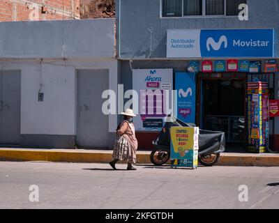 Desaguadero, Perù - 28 2022 luglio: Donna peruviana vestita di abbigliamento tradizionale e indossare una maschera è a piedi per la strada Foto Stock