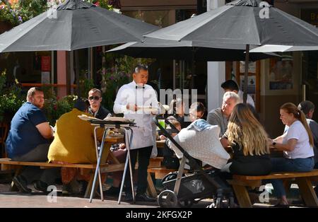 Un cameriere serve cene all'aperto in un ristorante a Santa Fe, New Mexico. Foto Stock