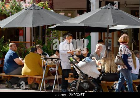 Un cameriere serve cene all'aperto in un ristorante a Santa Fe, New Mexico. Foto Stock