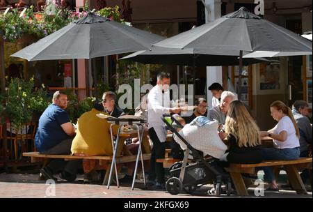 Un cameriere serve cene all'aperto in un ristorante a Santa Fe, New Mexico. Foto Stock