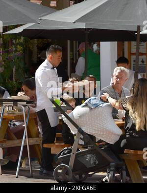 Un cameriere serve cene all'aperto in un ristorante a Santa Fe, New Mexico. Foto Stock