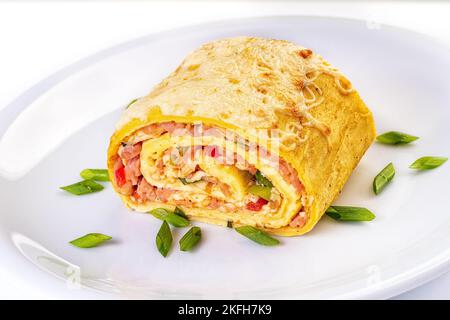 Rotolo d'uovo con carne, formaggio e cetrioli sottaceto primo piano in un piatto sul tavolo. Orizzontale Foto Stock