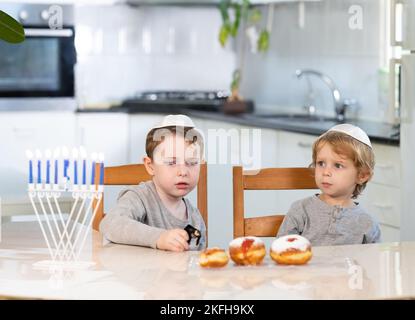 Padre e figli con la menorah celebrano hanukkah - festa religiosa ebraica Foto Stock