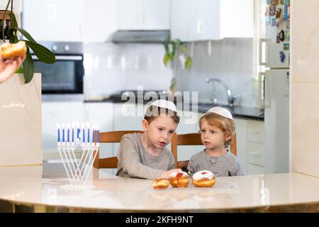 Padre e figli con la menorah celebrano hanukkah - festa religiosa ebraica Foto Stock