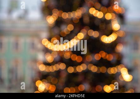 Natale sfondo festivo. Albero di Natale sfocato decorato con ghirlande leggere all'aperto in città Foto Stock